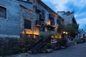 A traditional building with a staircase leading to the entrance, a signboard, and potted plants. - Tuoshui Ballad Courtyard Boutique Inn (Fenghuang)