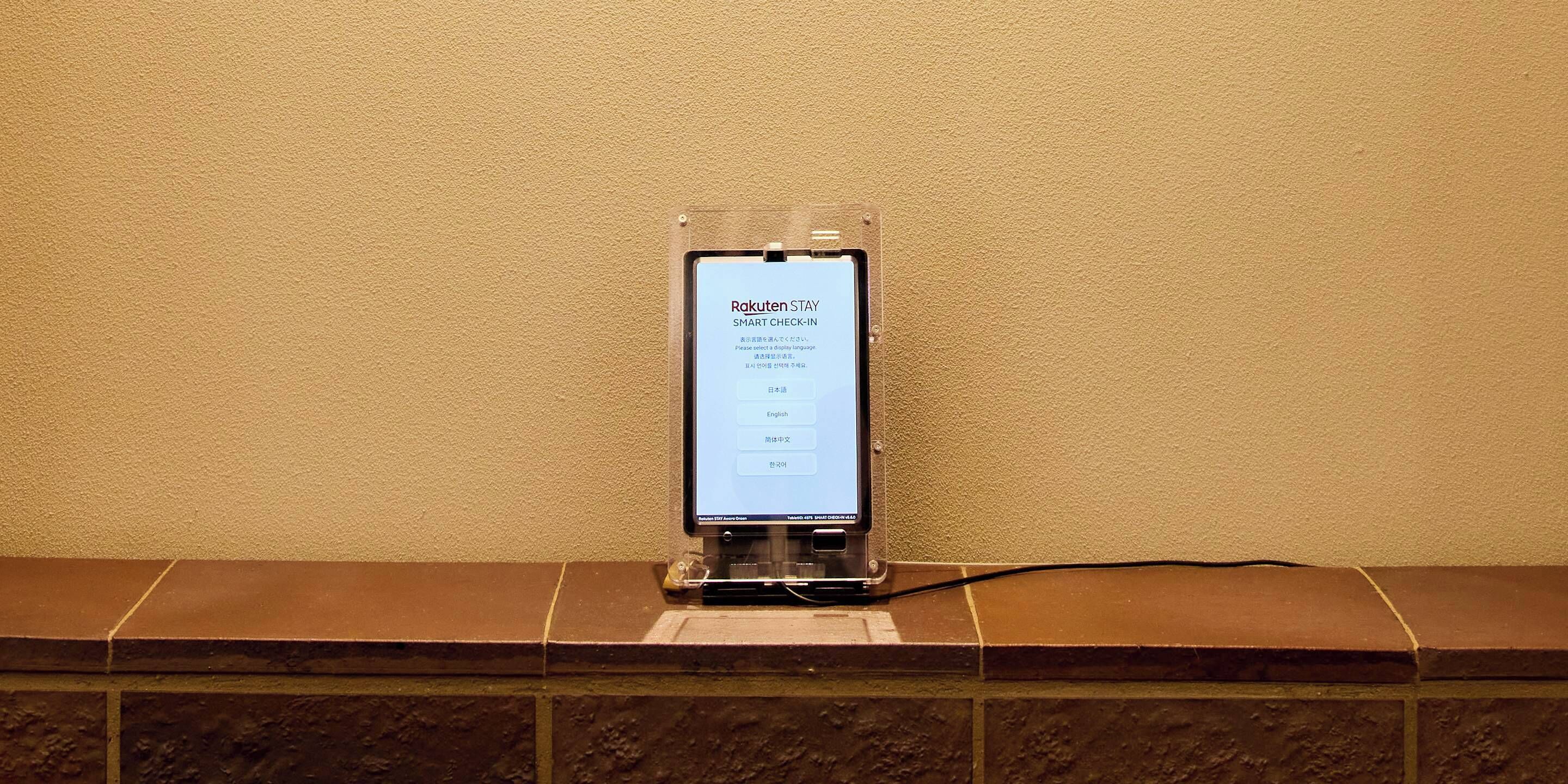 Un quiosco de registro digital con una pantalla que muestra texto en varios idiomas.