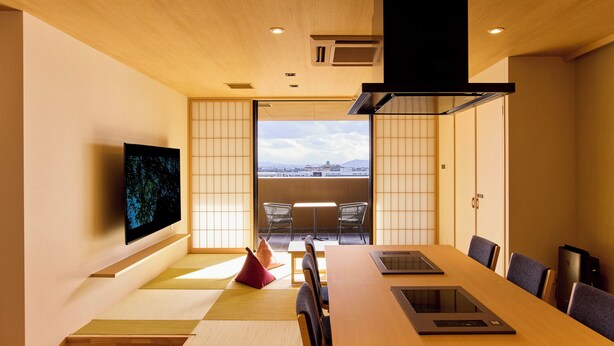 A modern meeting room with tatami flooring, a large table, and a view of a cityscape through a sliding door. - Rakuten STAY Awara Onsen (Awara)
