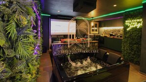 Area benessere con vasca idromassaggio, reception e parete con cartello 'Welcome to the Jungle'.