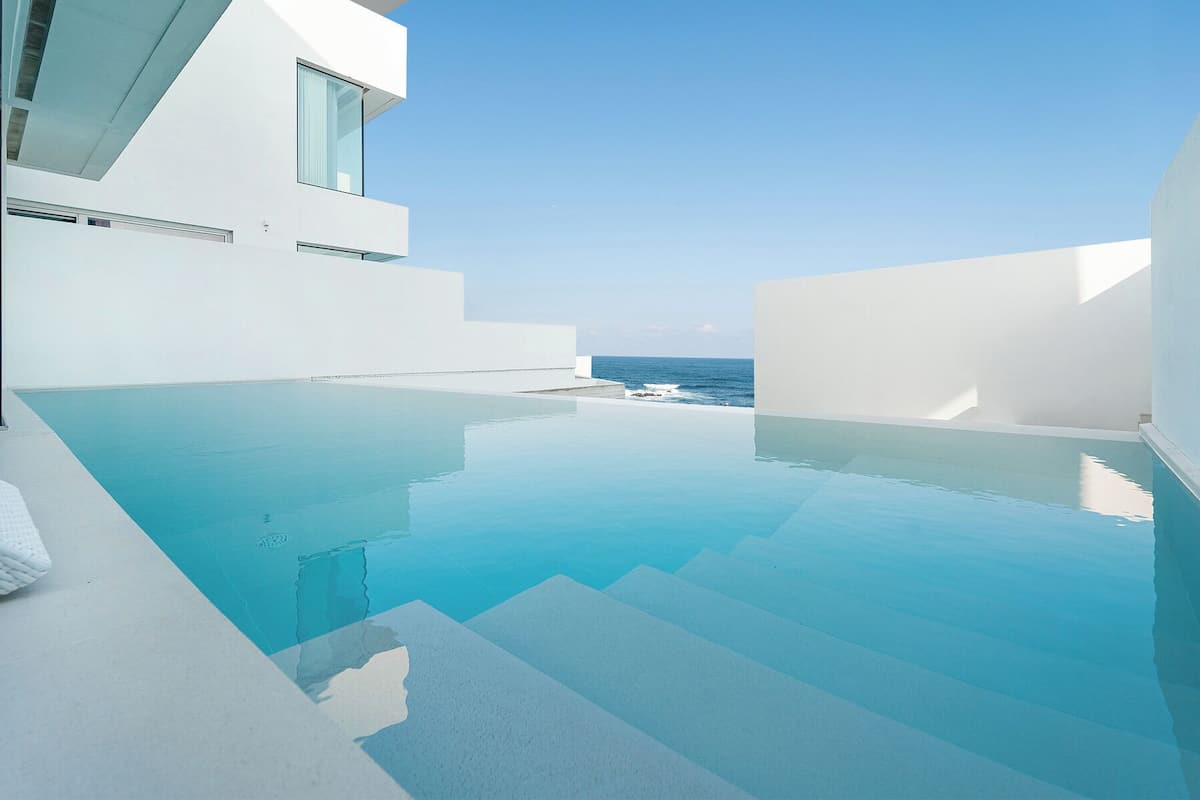A modern infinity pool with a clear view of the ocean.