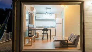 A modern kitchen with white cabinets, a dining table, and a sofa. - Gangneung Dawon-hill Pension (Gangneung)