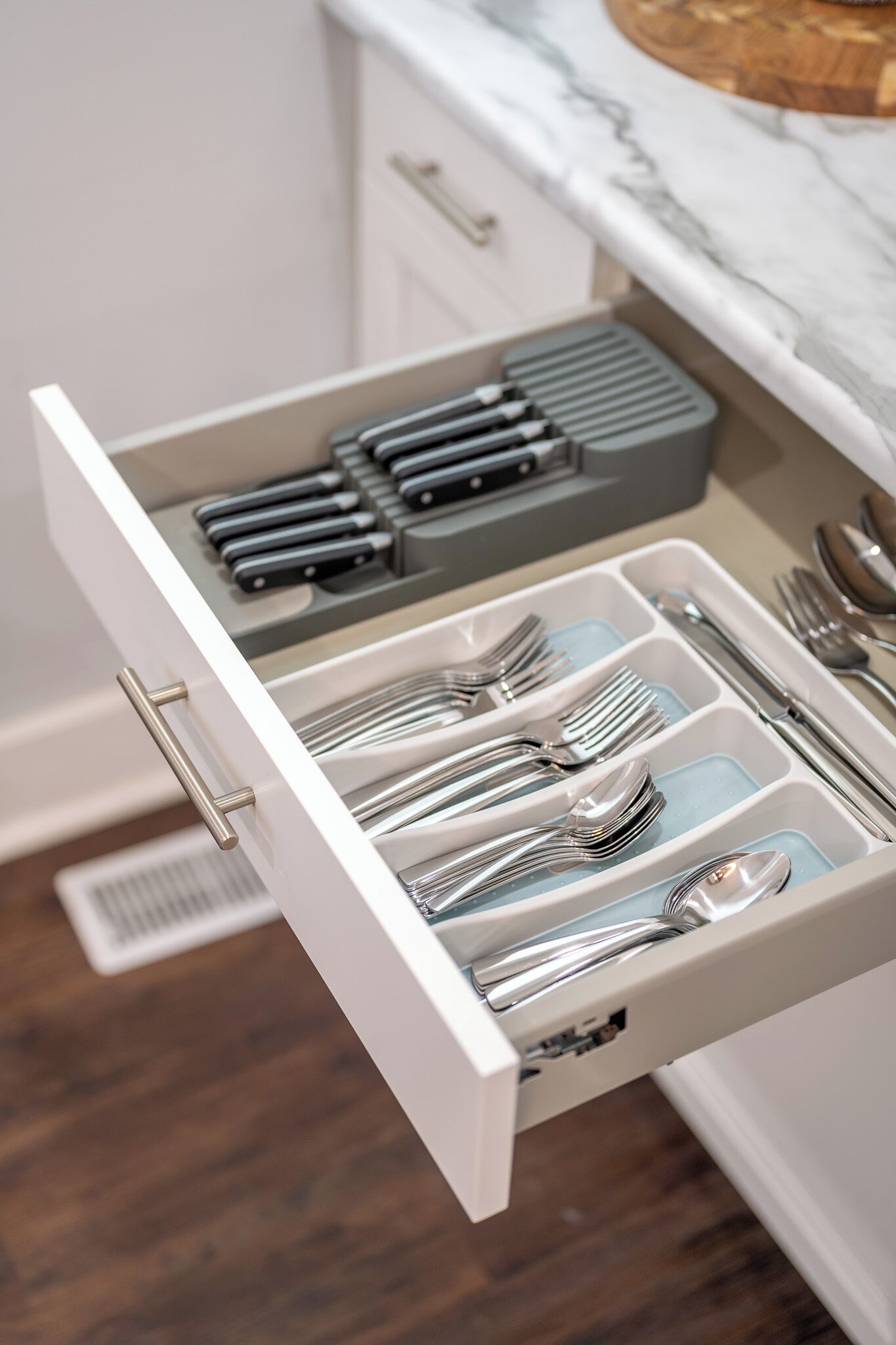 A drawer with utensils and a knife block.