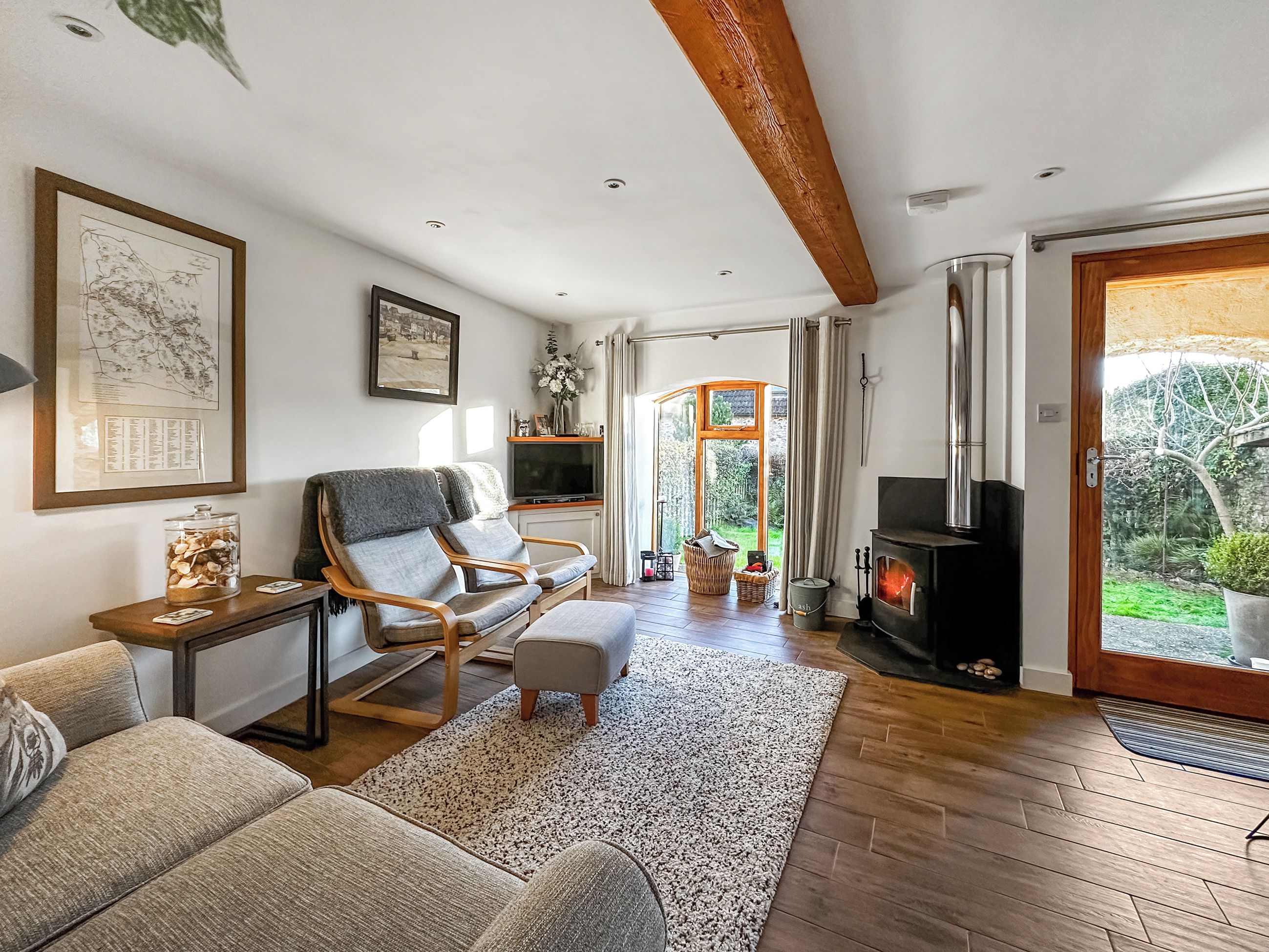 Un salon chaleureux avec une cheminée, des sièges confortables et une vue sur le jardin.