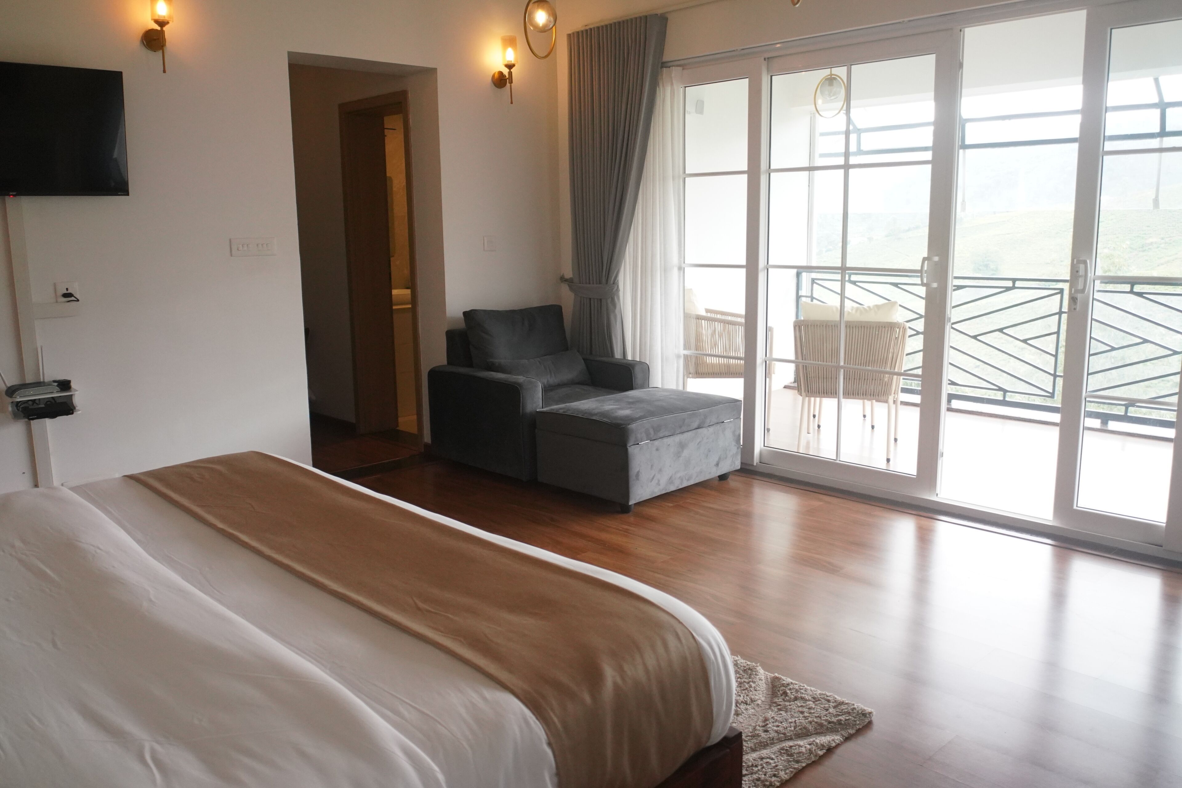 Une chambre avec un grand lit, un canapé et un balcon avec vue.