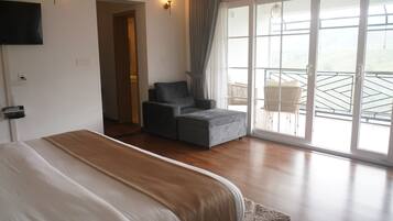 Une chambre avec un grand lit, un canapé et un balcon avec vue.