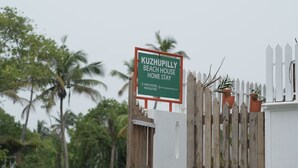 A sign for KUZHUPILLY BEACH HOUSE HOME STAY with contact information. - KUZHUPPILLY BEACH HOUSE (Kochi)