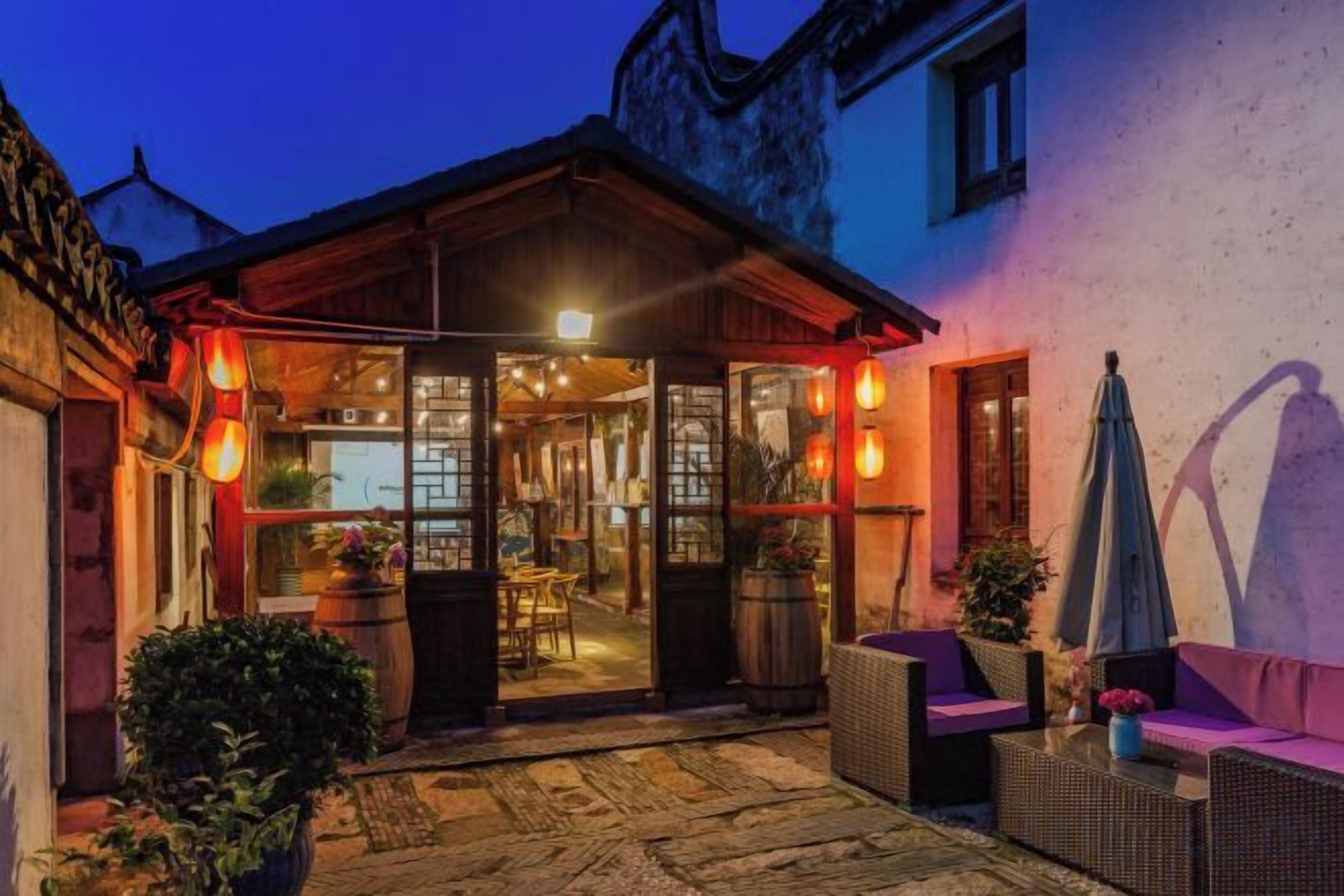 A cozy outdoor seating area with wicker furniture and a wooden pergola.