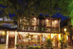 A traditional building with multiple stories, large windows, and a balcony. - Zhouzhuang Latte Play Stone Mulan Hotel (Kunshan)