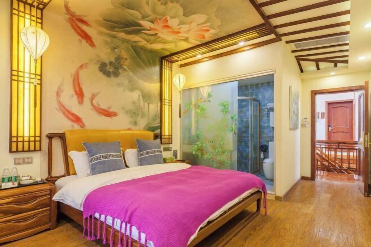Ein Schlafzimmer mit einem Bett, einem Holz-Kopfteil und einer großen Blumenmalerei an der Decke.