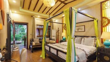 A four-poster bed with a canopy, a desk with a chair, and a television.