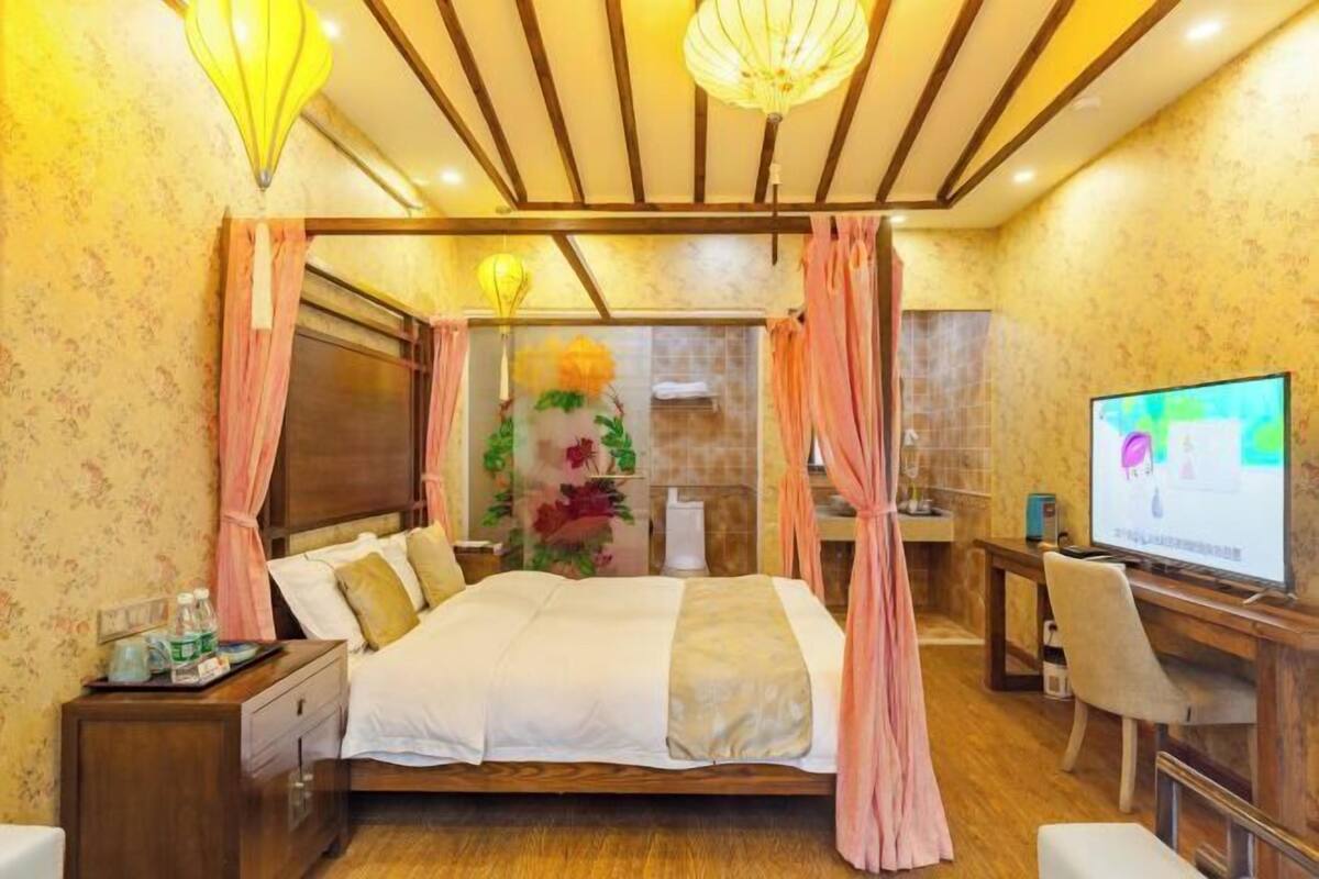 Ein Hotelzimmer mit Bett, Schreibtisch, Fernseher und Duschbereich.