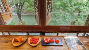 A wooden table with fruit bowls and a magazine. - Zhouzhuang Latte Play Stone Mulan Hotel (Kunshan)