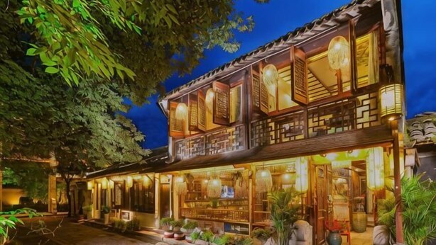 A traditional building with a wooden facade, large windows, and a balcony. - Zhouzhuang Latte Play Stone Mulan Hotel (Kunshan)