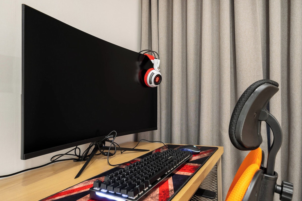 Una computadora con monitor, teclado y auriculares sobre un escritorio.