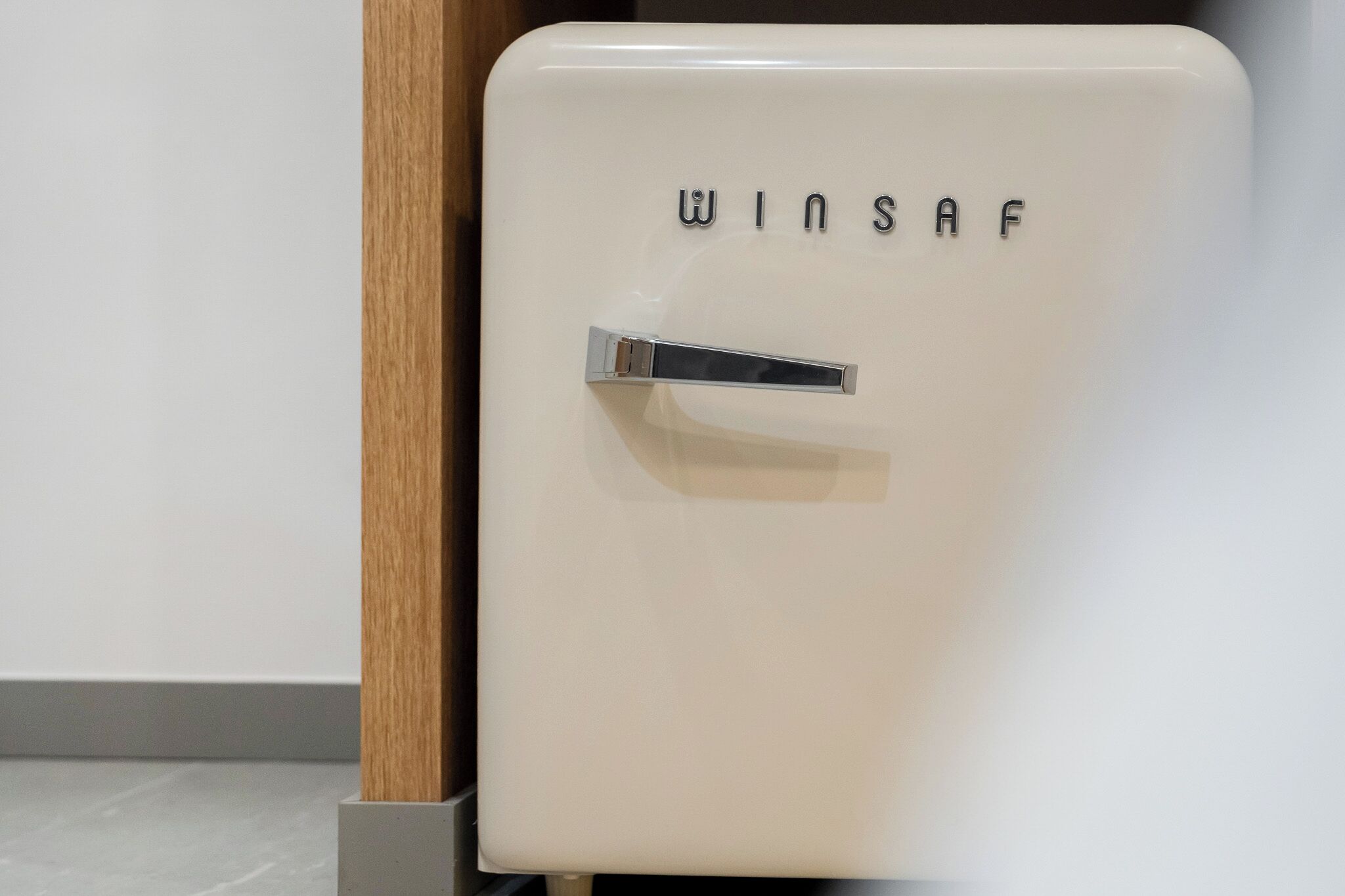 Un refrigerador blanco con el nombre de marca 'WINSAF' en la puerta.