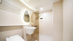 A modern bathroom with a toilet, sink, and shower area. - Hotel Urbanstay (Jeonju)