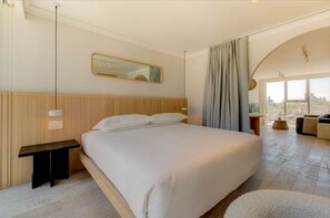 A modern hotel room with a large bed, a bedside table, a mirror, and a view of the city through large windows. - The Raven Multi Exclusive Trendy 1BR Apartment (Mexico City)