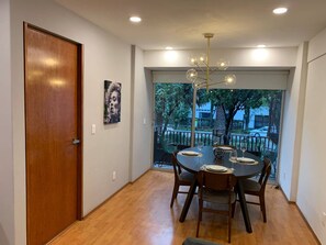 A dining area with a round table, chairs, and a chandelier. - Michelet Retreat Exclusive Modern 1BR Apartment (Mexico City)