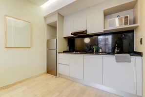 A modern kitchen with white cabinets, a black countertop, and a stainless steel refrigerator. - Aristoteles Elegance Comfort 1 BR Apartment wit (Mexico City)
