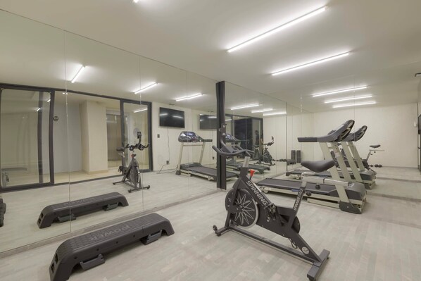 A gym with treadmills, stationary bikes, and a mirrored wall. - Aristoteles Elegance Comfort 1 BR Apartment wit (Mexico City)