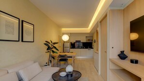 A modern living room with a sofa, a coffee table, and a dining area with a table and chairs. - Aristoteles Elegance Comfort 1 BR Apartment wit (Mexico City)