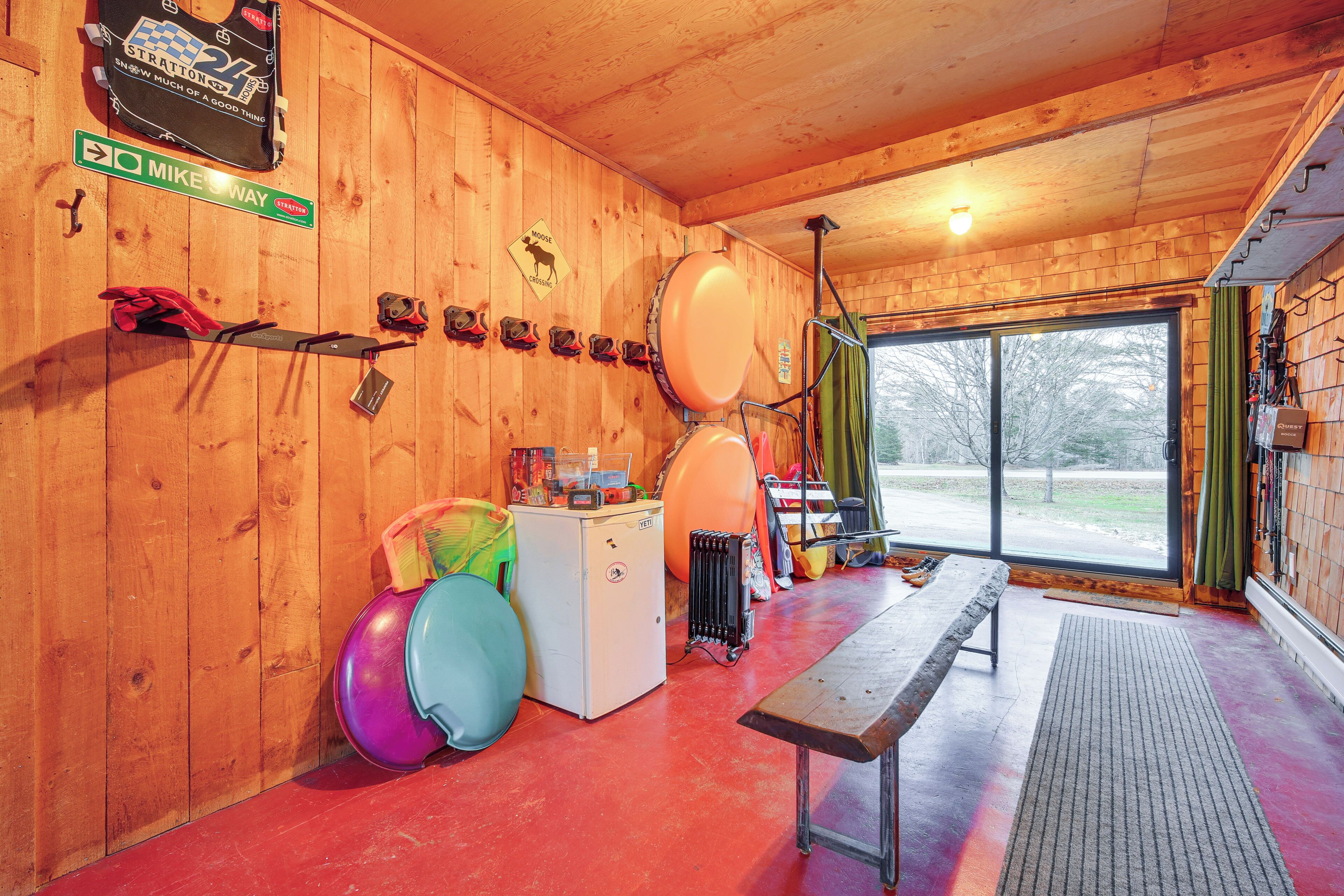 A wooden interior with a bench, exercise balls, a small fridge, and a window with a view.