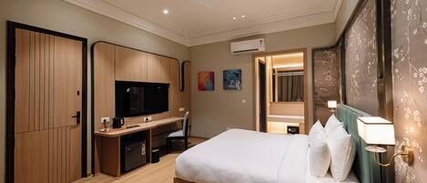 A hotel room with a bed, desk, TV, and a ceiling fan.