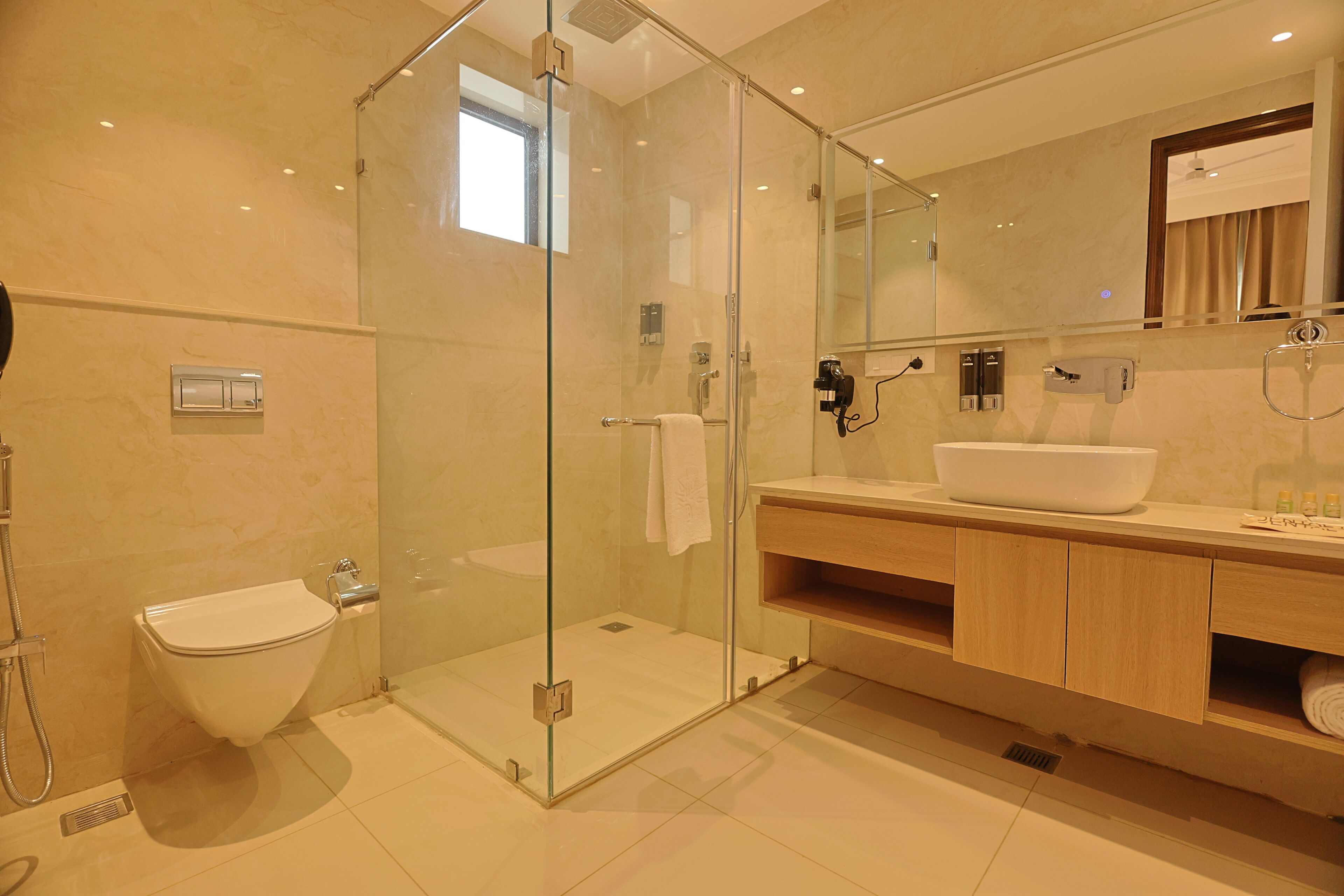 A modern bathroom with a glass-enclosed shower, a white sink, and a wooden vanity.