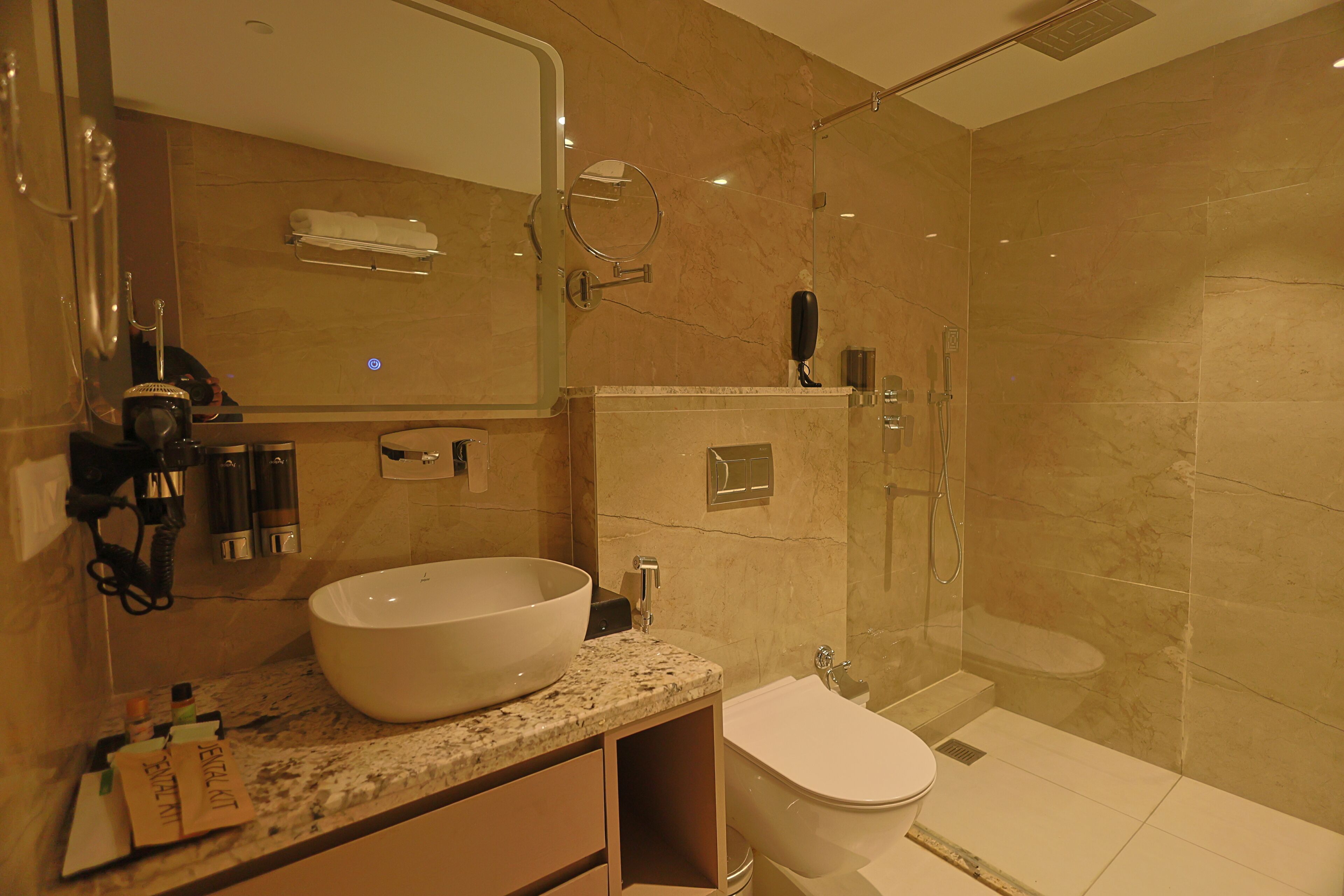 Un baño moderno con un lavabo grande, un inodoro, una ducha y un espejo.