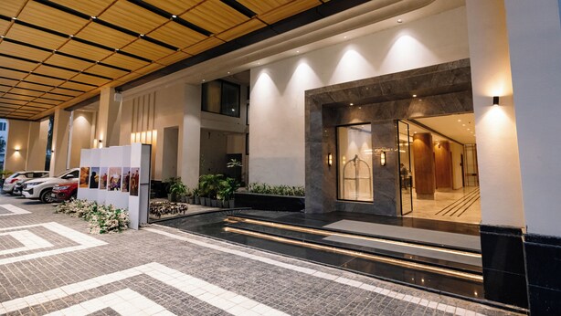 A modern hotel entrance with a tiled floor, a reception desk, and a staircase leading to the upper level. - Pride Premier Alwar, Sariska  (Alwar)