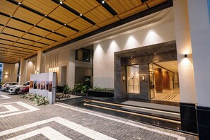 A modern hotel entrance with a tiled floor, a reception desk, and a staircase leading to the upper level. - Pride Premier Alwar, Sariska  (Alwar)