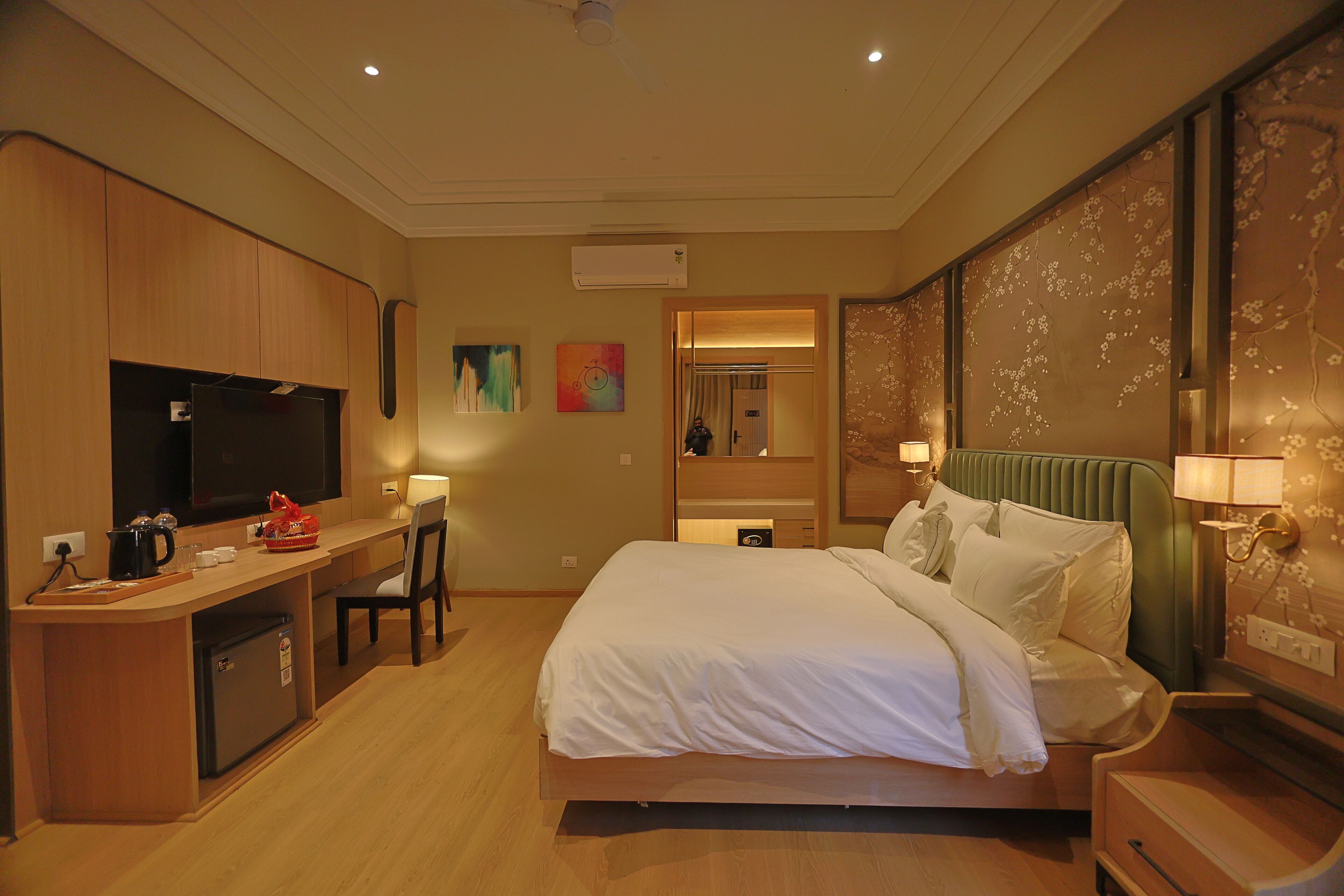 Una habitación de hotel con cama, escritorio y televisión.