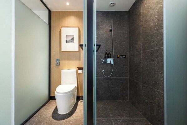 A modern bathroom with a toilet, a shower, and a wooden panel wall. - E Hotel-Kuanzhai Alley (Chengdu)
