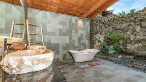 Een aparte badkuip en douche, een haardroger, badjassen, pantoffels