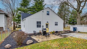A white single-story house with a front yard, a barbecue grill, and a small patio area. - Walk to Downtown Frankfort: Patio, Firepit & More! (Frankfort)