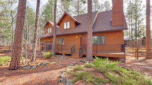 A cabin with a wooden exterior, a front porch, and a stone pathway leading to the entrance. - Golf, Hike, Explore! Family-Friendly Pinetop Haven (Pinetop Country Club)