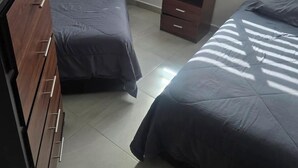 Makuuhuoneessa on kaksi sänkyä, puinen lipasto ja yöpöytä.