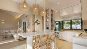 Een moderne keuken met een centraal eiland, witte kasten en uitzicht op het buitengebeuren.