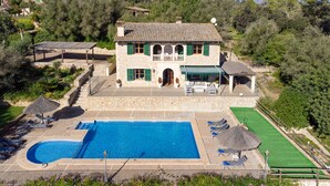 Une villa en pierre dotée d’une piscine, d’un espace salon extérieur et d’un jardin.