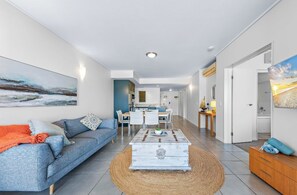 Un salon moderne avec un canapé, une table basse et des œuvres d’art accrochées aux murs.