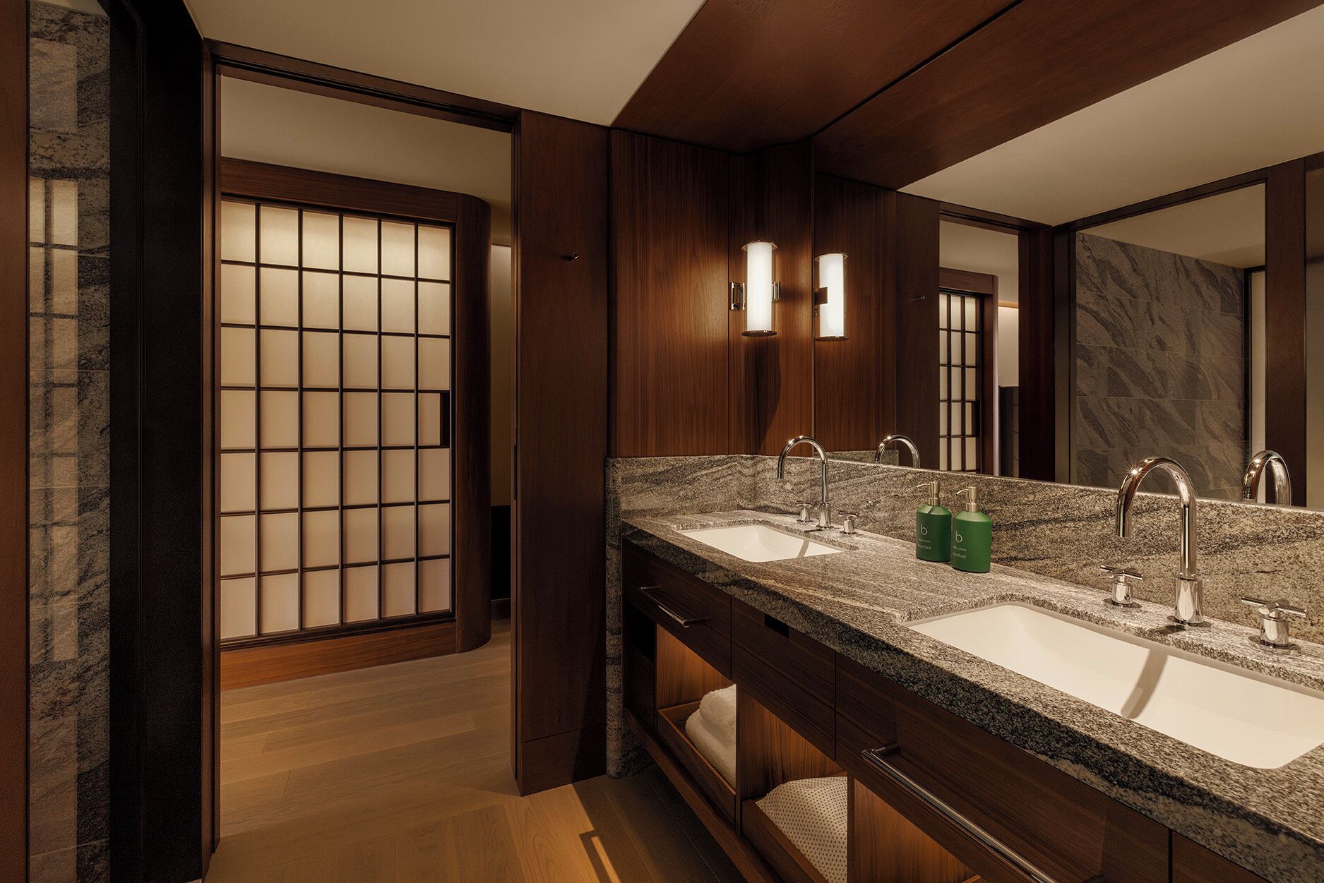 A modern bathroom with a wooden vanity, two sinks, and a large mirror.