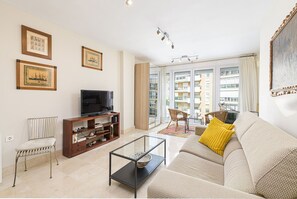 A living room with a sofa, a television, a bookshelf, and a dining area with a table and chairs. - Maestranza - Holiday rental Malaga city (Málaga)
