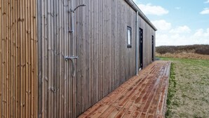 Un edificio in legno con un pontile di legno che conduce a una porta.