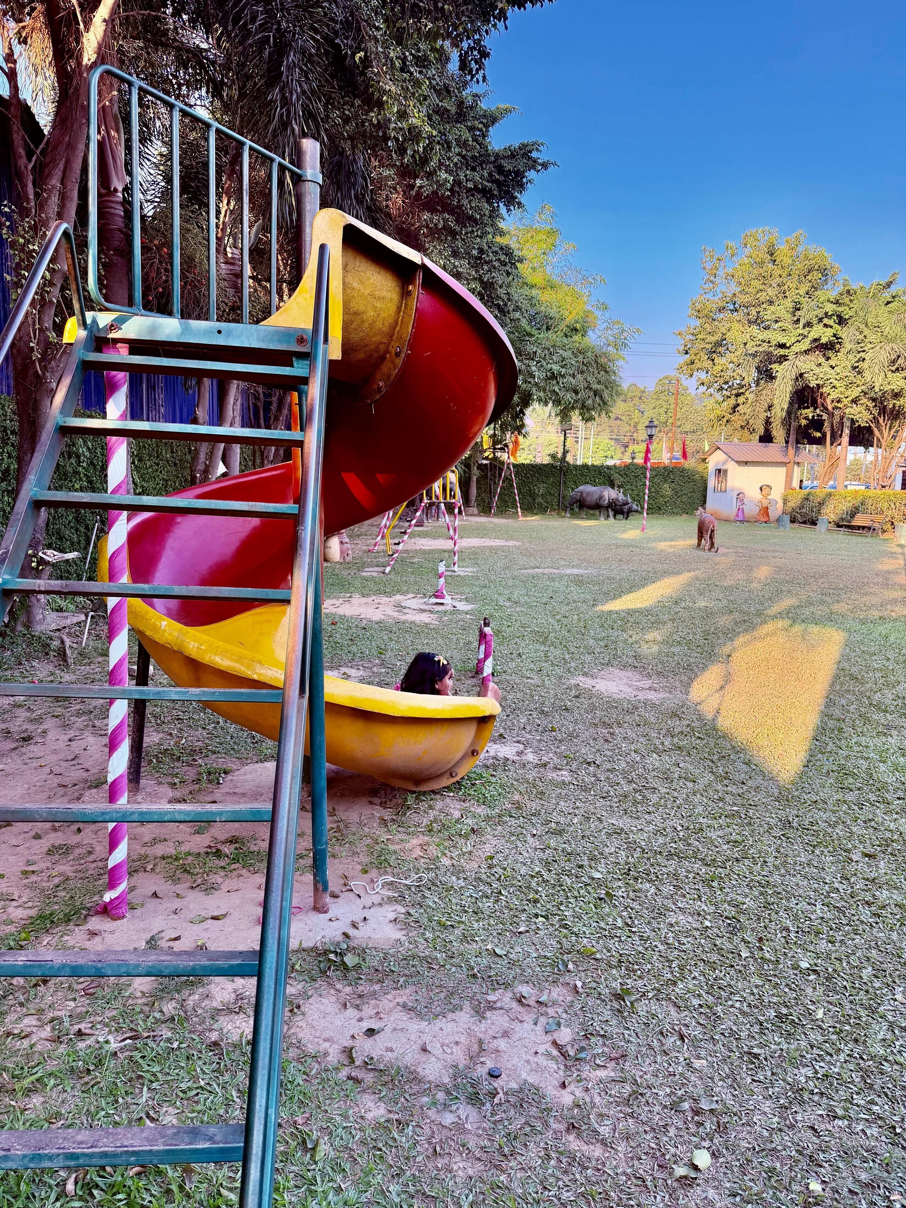 Ein Spielplatz mit einer Rutsche, einem gelben Boot und einer Kletterleiter.