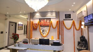 A reception area with a desk, computer, and a Buddha statue. - Hotel Shri Ram Ratan Inn (Ayodhya)