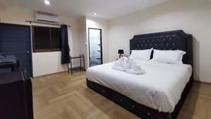 Une chambre d’hôtel avec un grand lit, un bureau et une armoire.