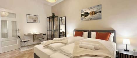 A bedroom with a large bed, a desk, and a chair.