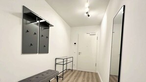 Ein Flur mit einer Bank, einem Spiegel und einer Tür.