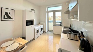 Una cocina moderna con comedor, lavadora y vistas al exterior.
